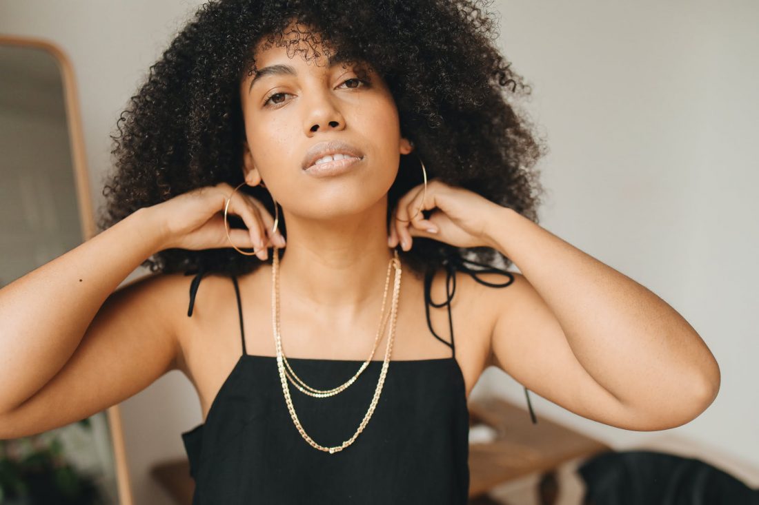 woman in black spaghetti strap top wearing necklace