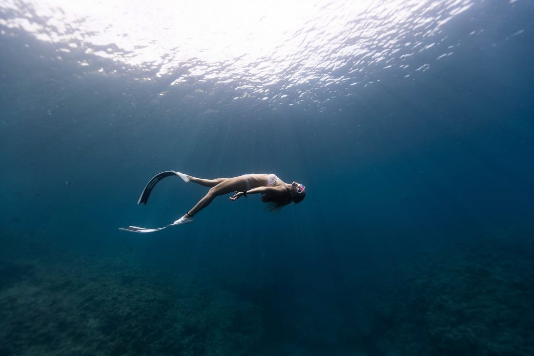anonymous graceful woman snorkeling in ocean